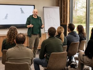Trainer hält ein Hundeseminar vor einer kleinen Gruppe