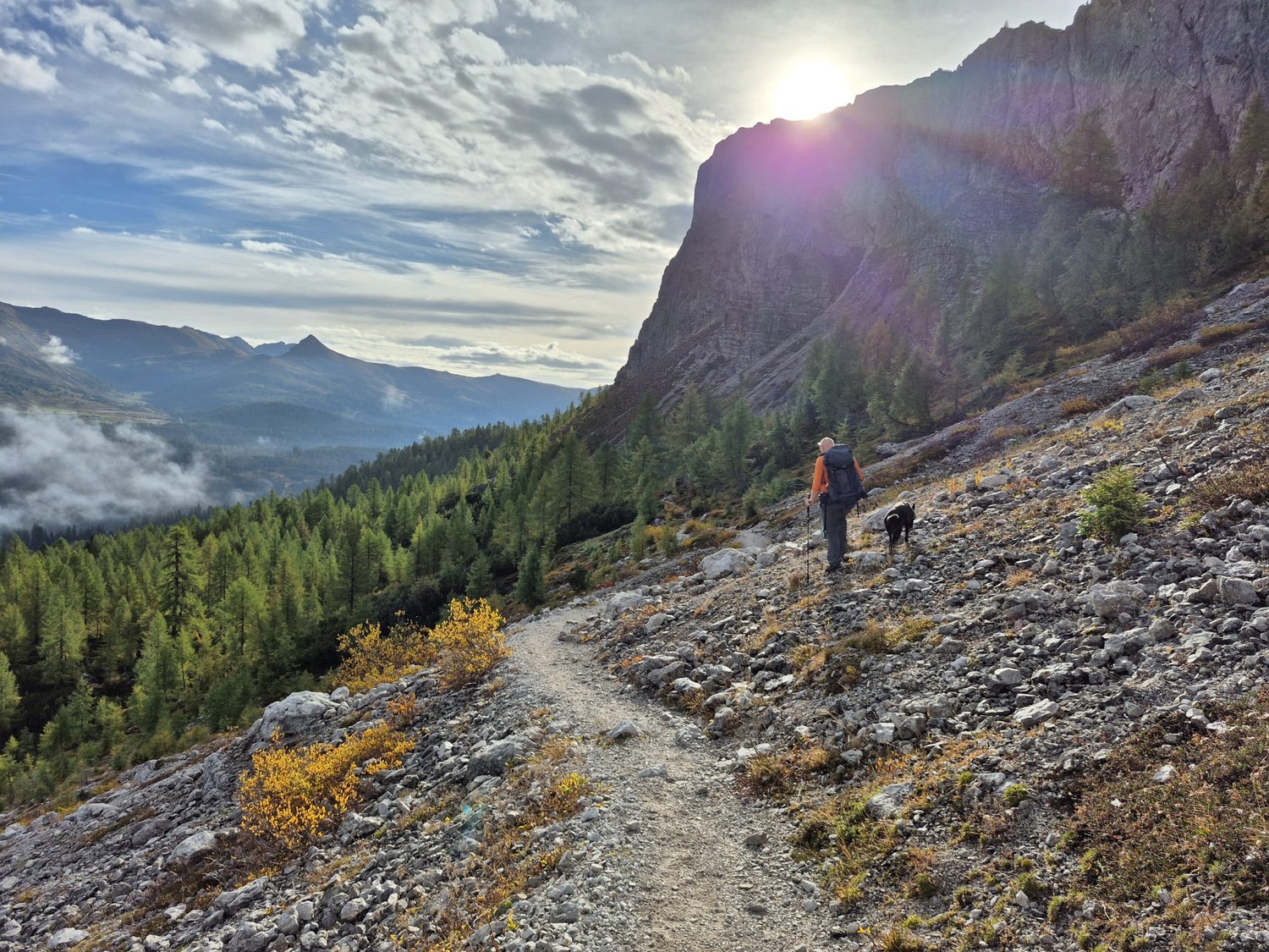 Jens Meyer wandert mit seinem Hund Chewie auf einem steinigen Bergpfad in den Alpen